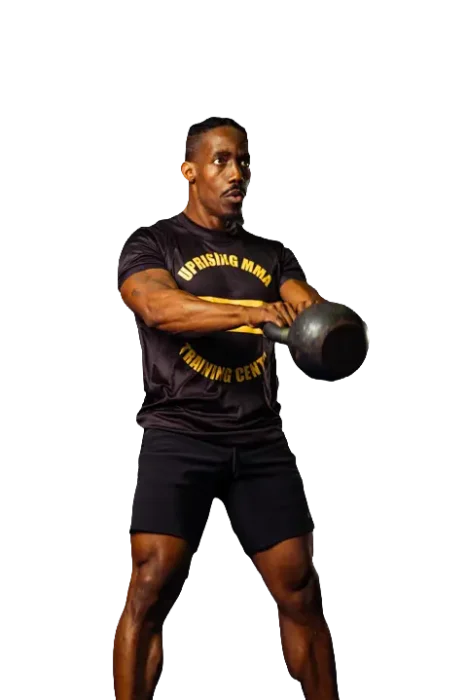 A man in a black Uprising MMA Training Center shirt and shorts performs a kettlebell swing exercise against a plain white background, showcasing the strength and technique honed at this top mma Las Vegas gym.